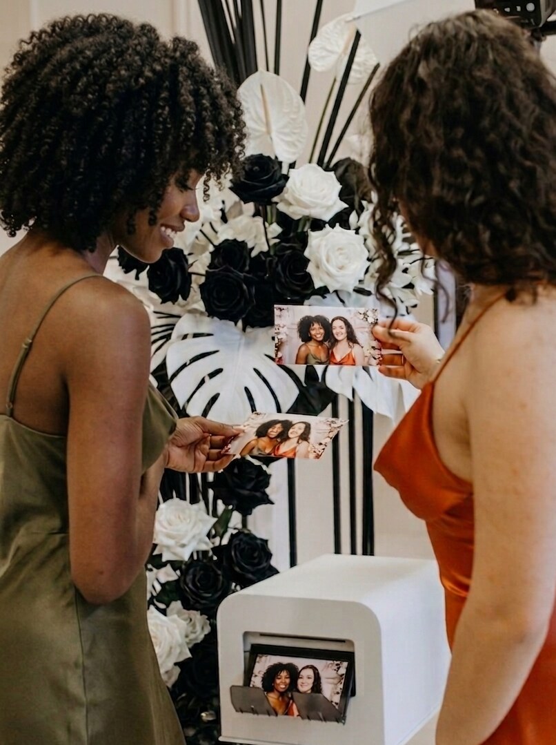 Gasten bekijken hun photobooth foto's bij een luxe Brothers.events booth